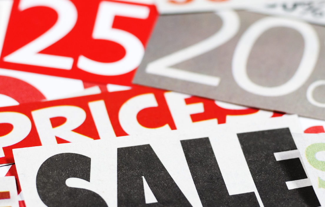 Sales promotional signage on a table with red, white, gray, and black colors. | Promotional and Loyalty Print Solutions