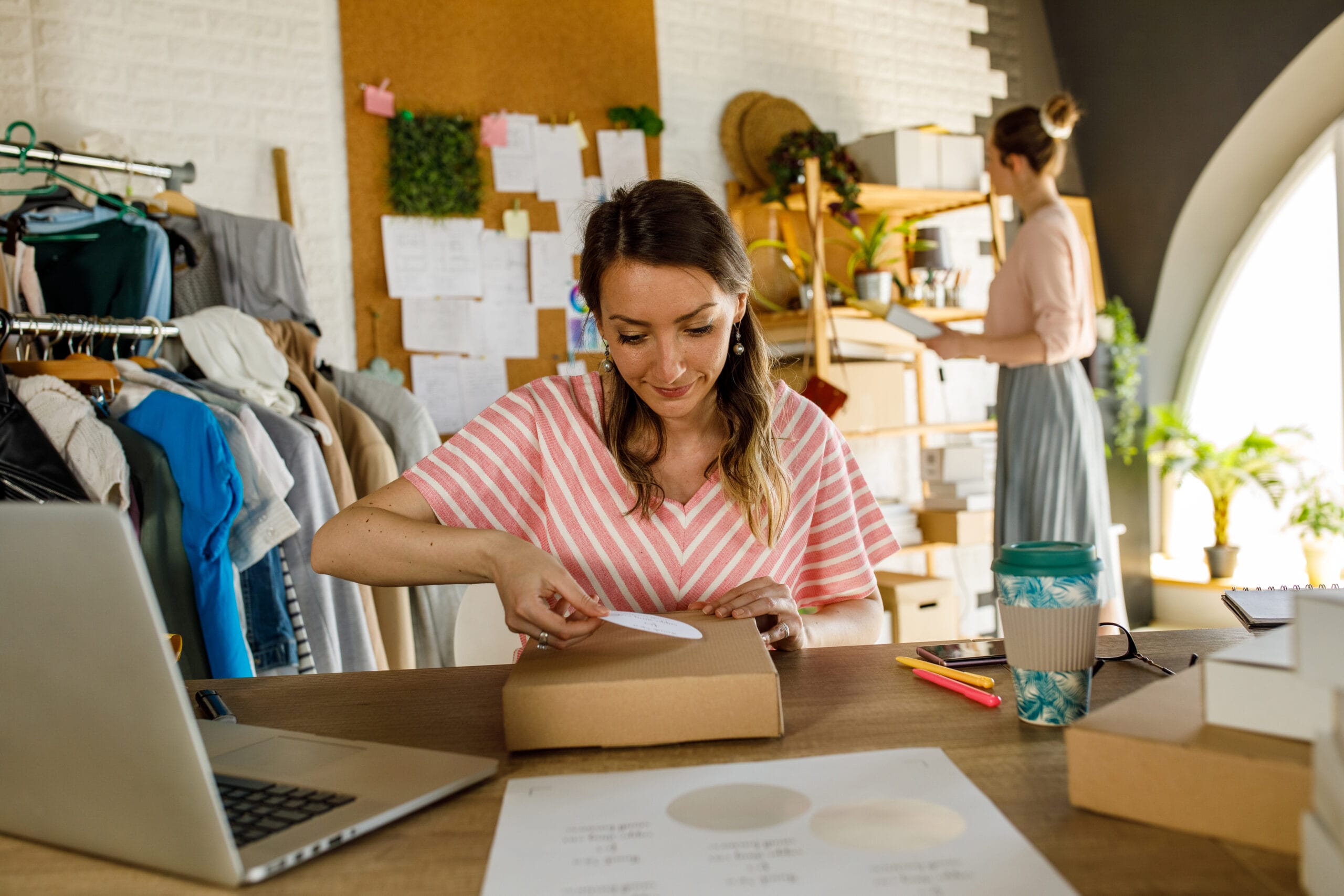 diligent young businesswoman sitting at her desk and labeling a package.